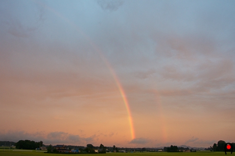 夕焼け空に掛かる2重虹の写真