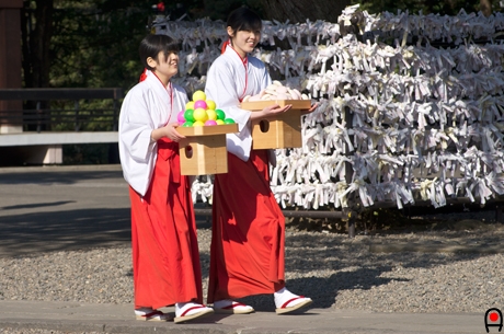 神楽殿へ供物を運ぶ巫女達の写真