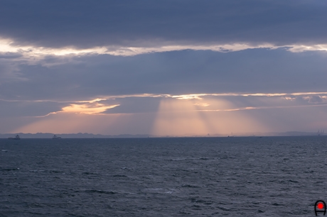 海ほたるから見えた東京湾に射す夕日の斜光の写真